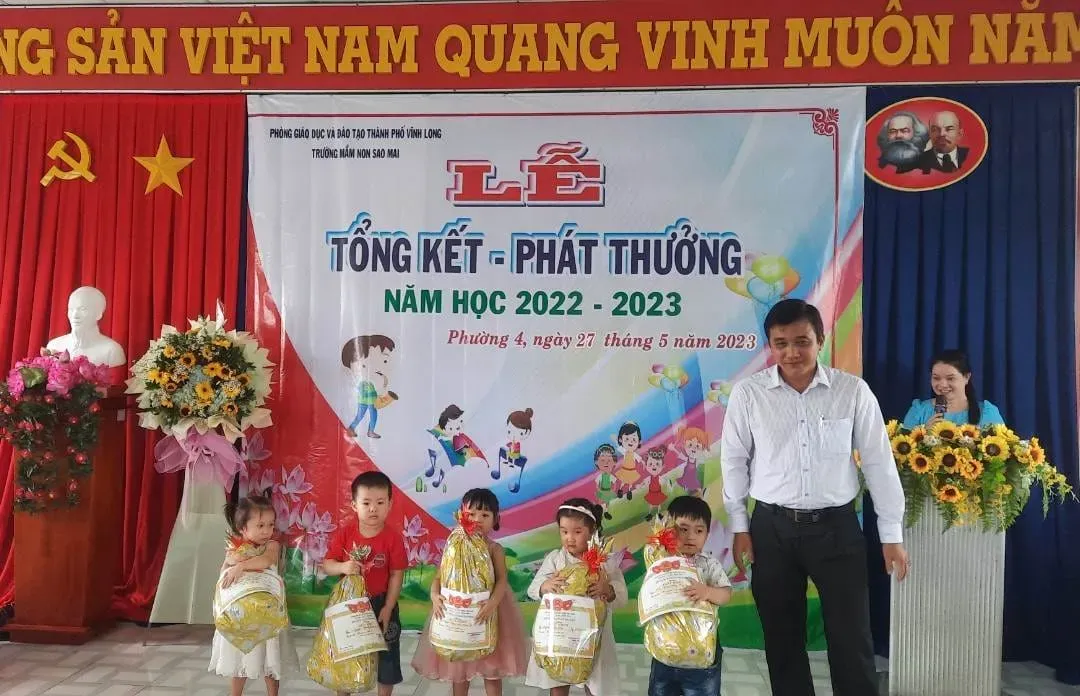 Các bé mầm non đang vui đùa, cười nói hồn nhiên trong sân trường, thể hiện sự hồn nhiên và hạnh phúc dưới sự dìu dắt của thầy cô
