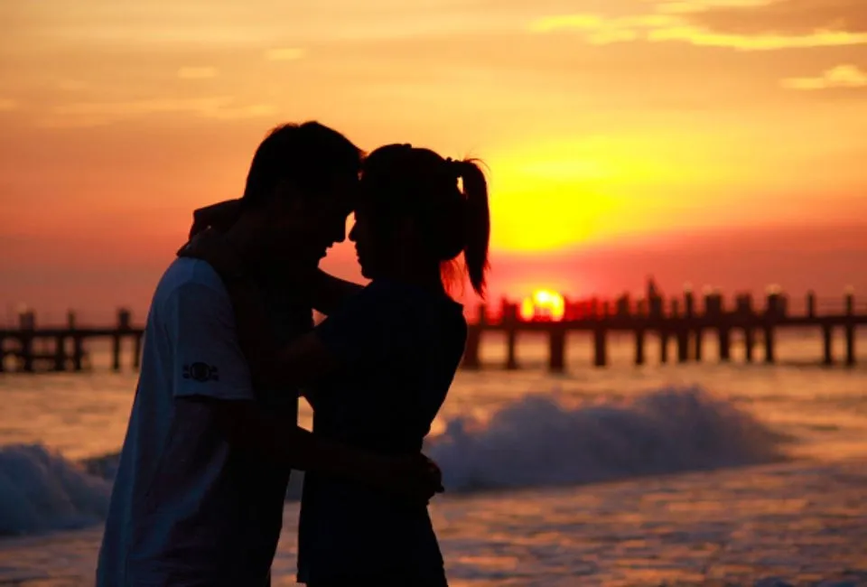 Hình ảnh một cô gái trẻ đang mỉm cười rạng rỡ, cầm điện thoại nhắn tin buổi sáng, thể hiện sự vui vẻ và lạc quan khi nhận được lời chúc ngày mới lãng mạn.