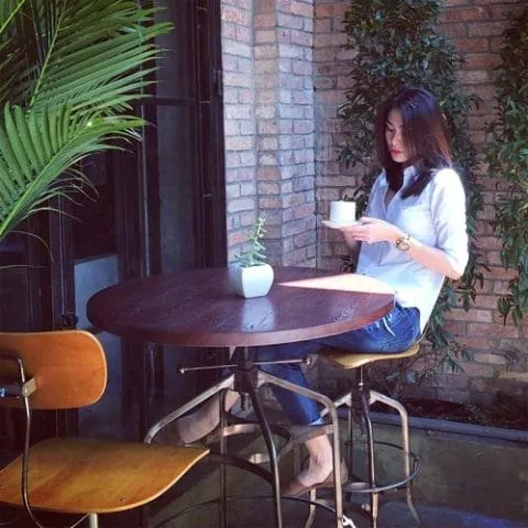 Ánh sáng dịu nhẹ đổ xuống ly nước trên bàn gỗ tạo cảm giác cô đơn