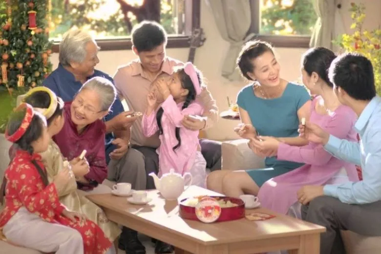 Con cháu kính cẩn trao gửi lời chúc ông bà năm mới thể hiện truyền thống đạo hiếu