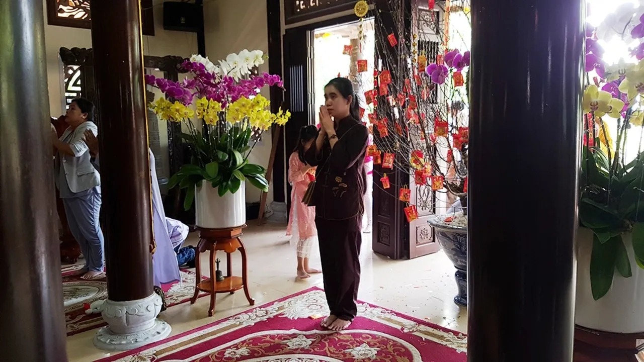 Phật tử trang nghiêm đi vào chính điện để thực hiện nghi lễ bái Phật cầu an cho gia đình