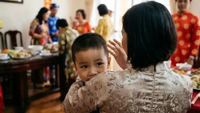 Trẻ nhút nhát ngại ngùng khi đi chúc Tết phải nấp sau lưng mẹ