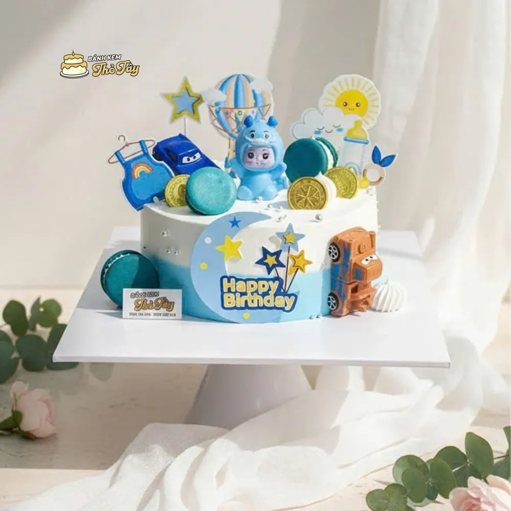 Bánh sinh nhật thôi nôi bé trai Mẫu bánh được thiết kế đáng yêu với tone xanh - trắng nhẹ nhàng, họa tiết ngộ nghĩnh phù hợp cho bé tròn 1 tuổi. Bánh mang ý nghĩa chúc mừng bé lớn khôn, khỏe mạnh, hay ăn chóng lớn và gặp nhiều may mắn trong chặng đường đầu đời. Cốt bánh mềm mịn, kem ngọt dịu, an toàn và dễ ăn - lựa chọn hoàn hảo cho buổi tiệc thôi nôi ấm áp, trọn vẹn yêu thương của gia đình.