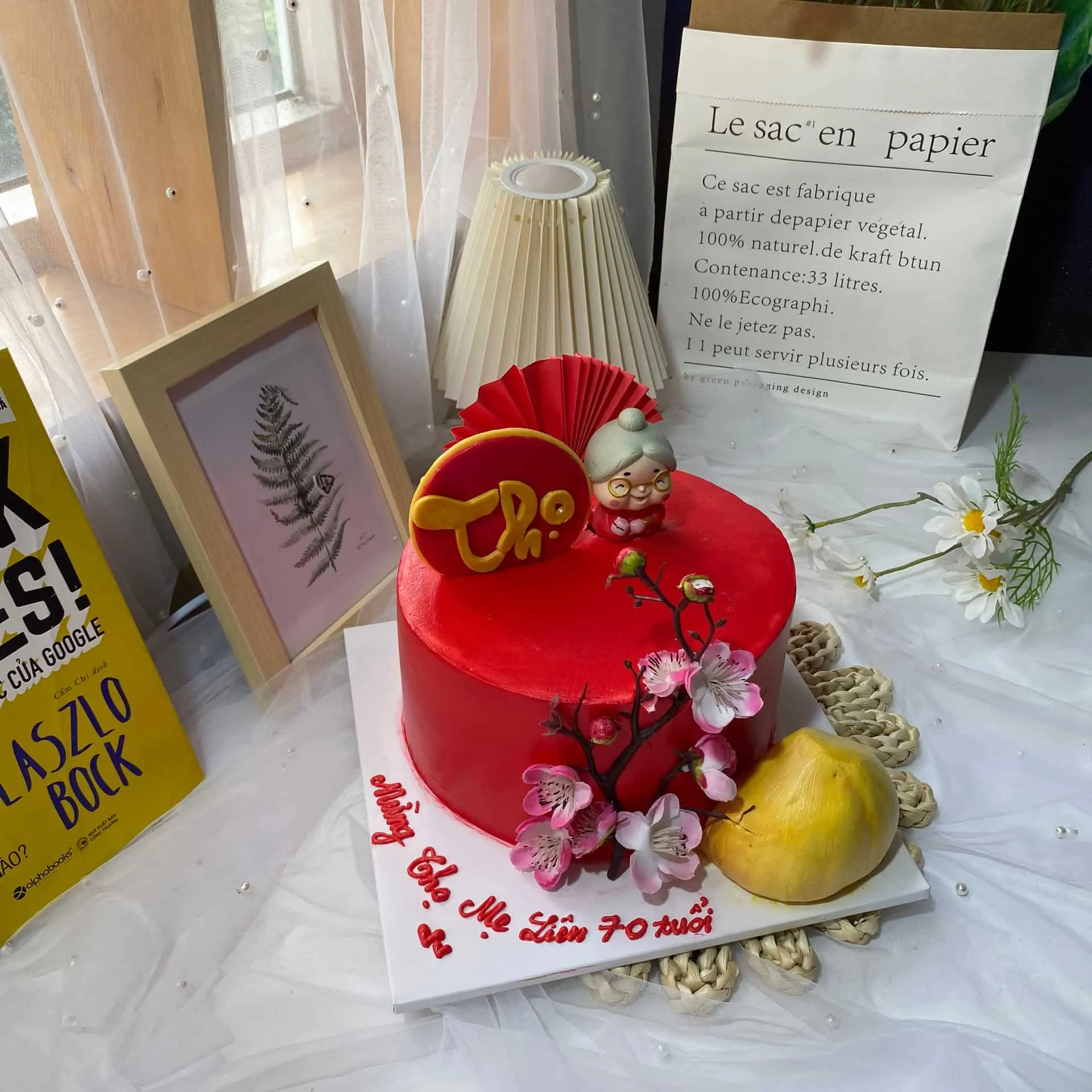 Bánh sinh nhật màu đỏ trang trí hoa và chữ Thọ truyền thống