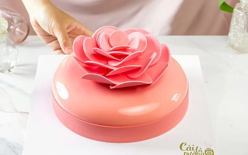 Bánh kem bơ với hoa hồng kem bơ màu hồng phấn, điểm vải tươi