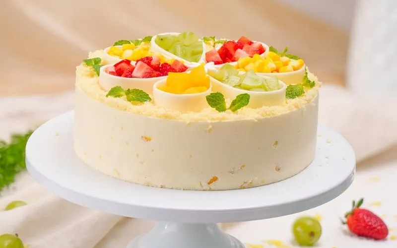 Bánh kem bơ với hoa bắp dâu tím pastel, lá xanh tự nhiên