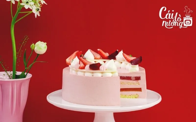 Bánh mousse ổi hồng với gradient màu hồng cam, trang trí hoa tươi