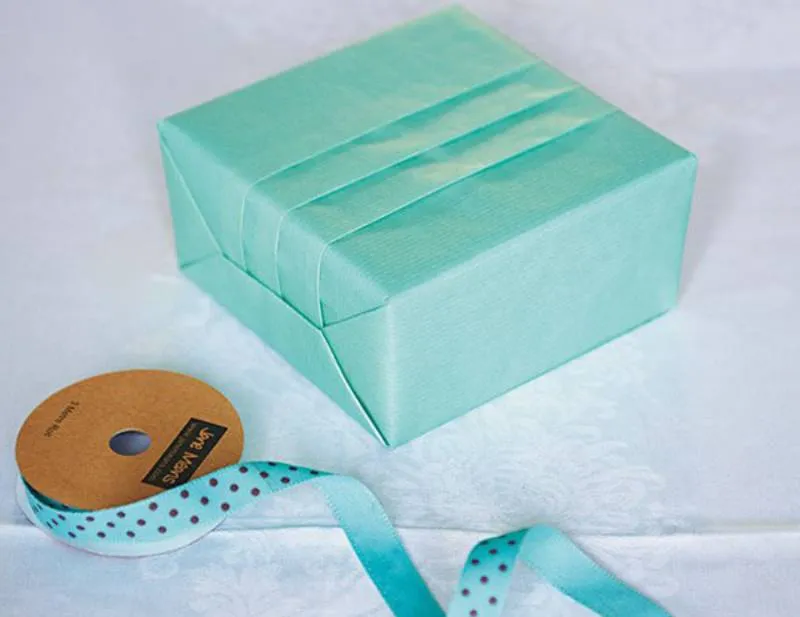 Hộp quà sinh nhật với nơ ruy băng xanh nổi bật