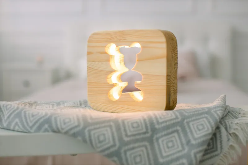 Đèn ngủ gỗ ánh vàng nhẹ.