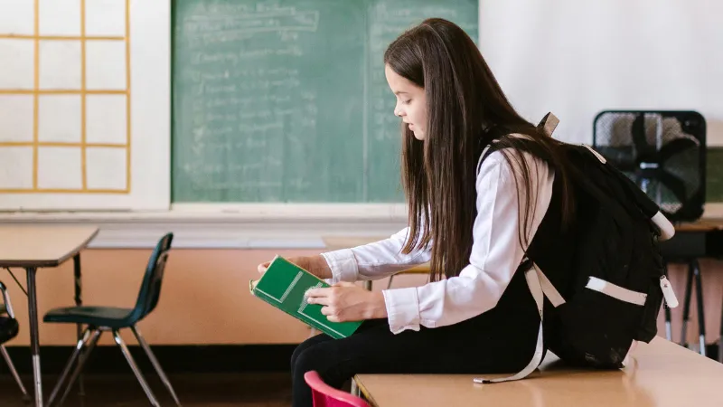 Học sinh đeo balo trong lớp